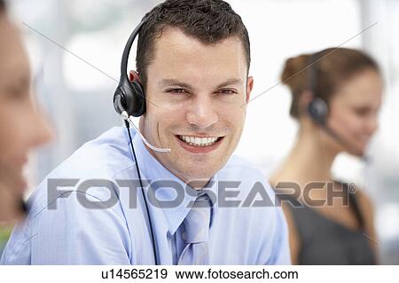 Young businessman wearing headset View Large Photo Image Stock Photo - Young businessman wearing headset. Fotosearch