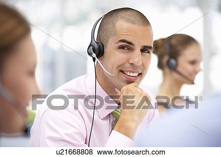 Stock Photo - Young businessman wearing headset. Fotosearch