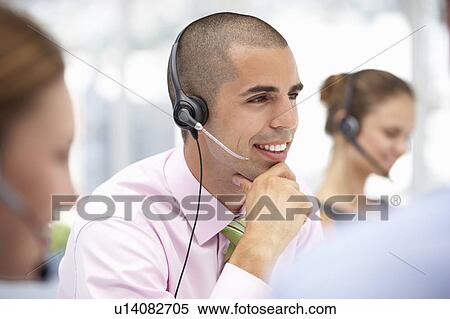 Stock Photography - Young businessman wearing headset. Fotosearch