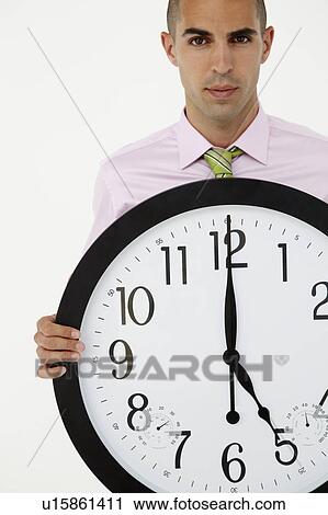 Young businessman with giant clock View Large Photo Image Stock Image - Young businessman with giant clock. Fotosearch