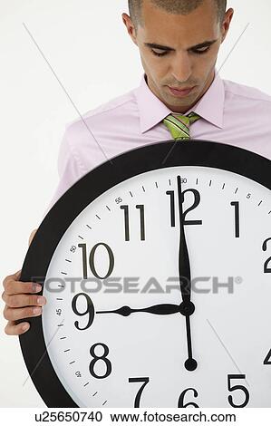 Young businessman with giant clock View Large Photo Image Stock Image - Young businessman with giant clock. Fotosearch