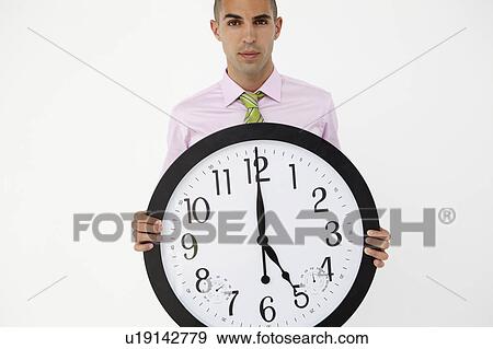 Young businessman with giant clock View Large Photo Image Stock Photo - Young businessman with giant clock. Fotosearch