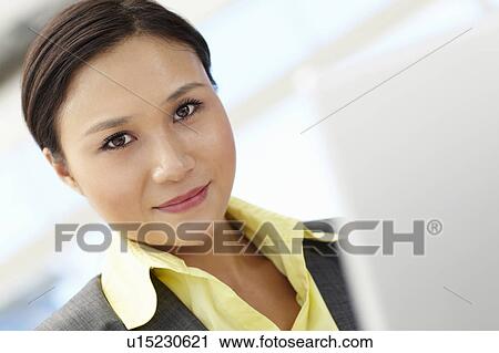 Stock Image - Young businesswoman using laptop. Fotosearch