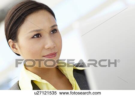 Stock Photography - Young businesswoman using laptop. Fotosearch