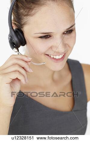Stock Image - Young businesswoman wearing headset. Fotosearch
