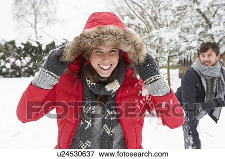 Stock Photo - Young couple having snowball fight. Fotosearch