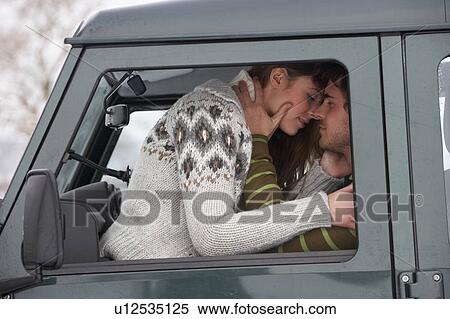 Stock Photography - Young couple in car in snow. Fotosearch