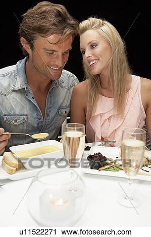 Stock Image - Young couple in restaurant. Fotosearch