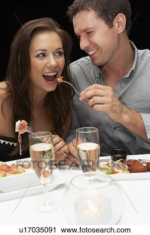 Stock Image - Young couple in restaurant. Fotosearch