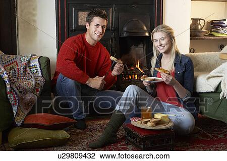 Stock Image - Young couple making toast on open fire. Fotosearch