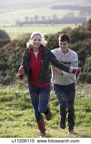 Stock Image - Young couple on country walk. Fotosearch