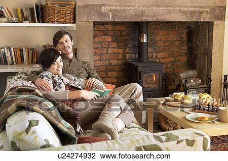Young couple relaxing by fire View Large Photo Image Stock Image - Young couple relaxing by fire. Fotosearch