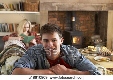 Young couple relaxing by fire View Large Photo Image Stock Photo - Young couple relaxing by fire. Fotosearch