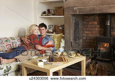 Young couple relaxing by fire View Large Photo Image Stock Photograph - Young couple relaxing by fire. Fotosearch
