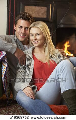 Young couple sitting by open fire View Large Photo Image Stock Image - Young couple sitting by open fire. Fotosearch