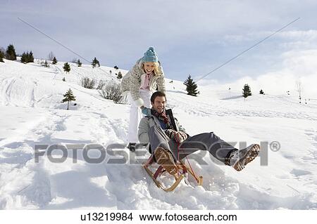 Picture - Young Couple Sledding. Fotosearch