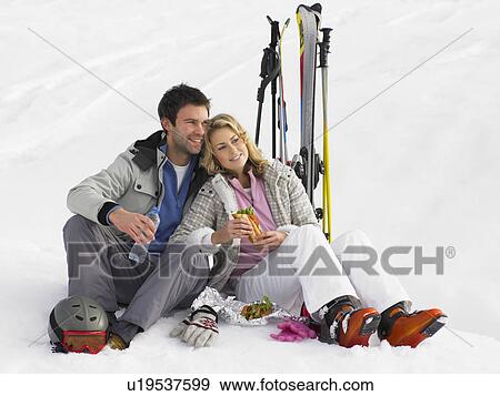 Stock Photo - Young Couple With Picnic On Ski Vacation. Fotosearch