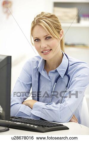 Stock Photograph - Young doctor at desk. Fotosearch