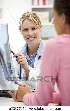 Stock Image - Young doctor with female patient. Fotosearch