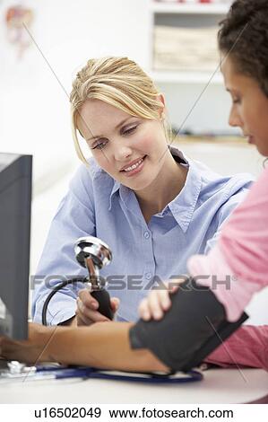 Stock Photo - Young doctor with female patient. Fotosearch