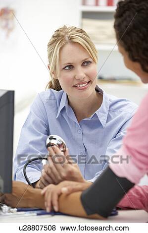 Young doctor with female patient View Large Photo Image Stock Photo - Young doctor with female patient. Fotosearch