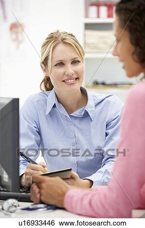Stock Photograph - Young doctor with female patient. Fotosearch