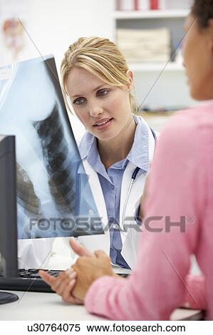 Stock Photography - Young doctor with female patient. Fotosearch