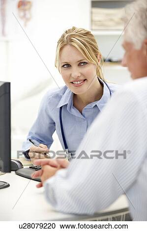 Stock Image - Young doctor with senior patient. Fotosearch