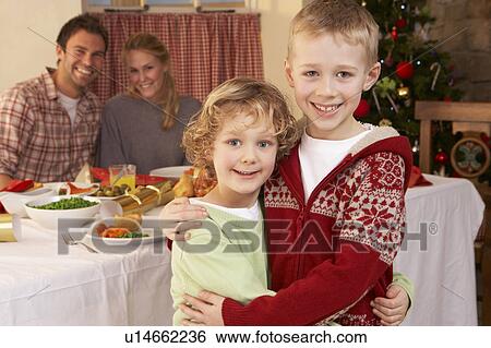 Stock Photograph - Young family at Christmas dinner table. Fotosearch