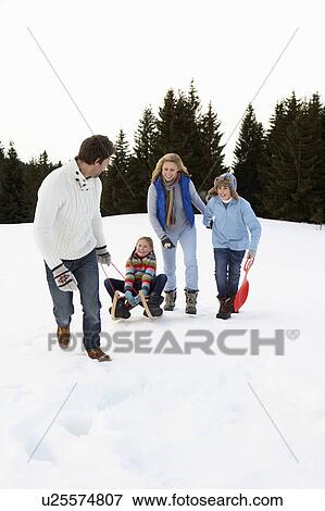 Stock Photo - Young Family In Alpine Snow Scene With Sled. Fotosearch