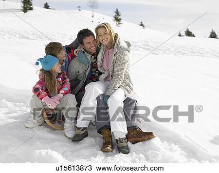 Young Family Sitting On A Sled In The Snow View Large Photo Image Stock Image - Young Family Sitting On A Sled In The Snow. Fotosearch