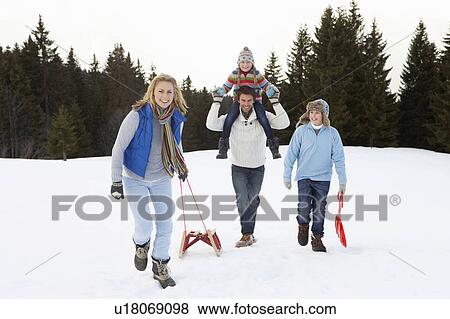 Stock Photo - Young Family Walking Through Snow With Sled. Fotosearch