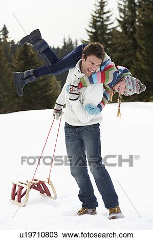 Stock Image - Young Father And Daughter In Snow With Sled. Fotosearch