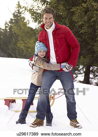 Stock Photo - Young Father And Daughter In Snow With Sled. Fotosearch