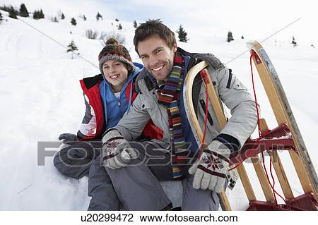 Stock Image - Young Father And Son In Snow With Sled. Fotosearch