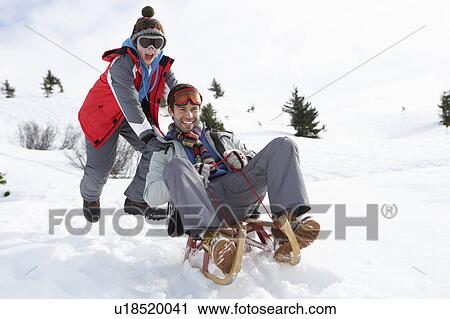 Stock Image - Young Father And Son Sledding. Fotosearch