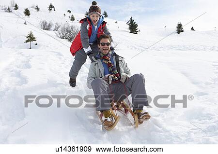 Stock Photo - Young Father And Son Sledding. Fotosearch