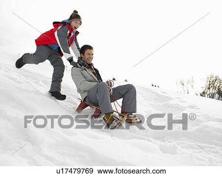 Stock Photo - Young Father And Son Sledding. Fotosearch