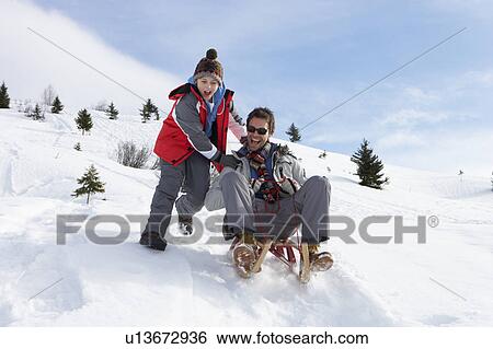 Stock Photograph - Young Father And Son Sledding. Fotosearch