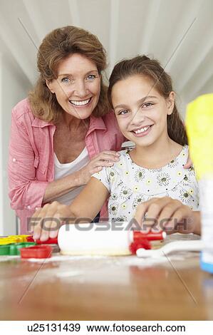 Stock Photo - Young girl baking with grandmother. Fotosearch