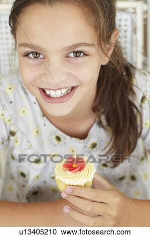 Young girl with cupcake View Large Photo Image Stock Image - Young girl with cupcake. Fotosearch