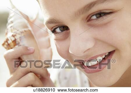 Young girl with seashell View Large Photo Image Stock Image - Young girl with seashell. Fotosearch