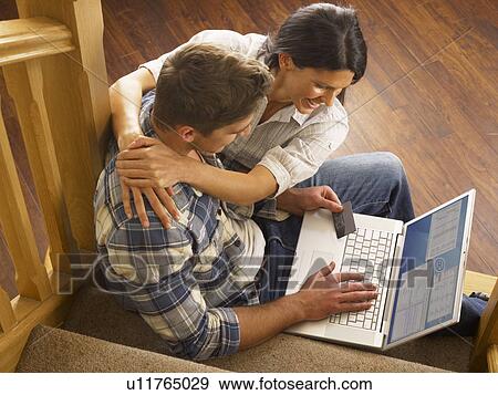 Stock Photo - Young Hispanic couple shopping online. Fotosearch