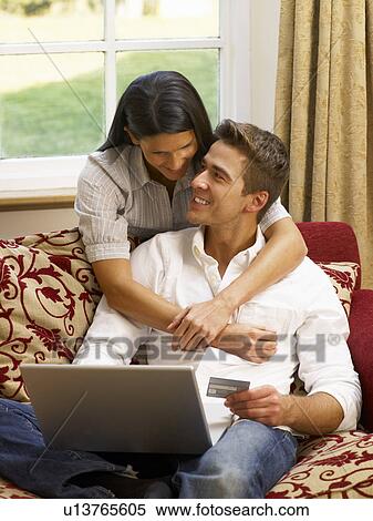Stock Photography - Young Hispanic couple shopping online. Fotosearch