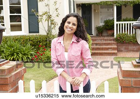 Stock Photography - Young Hispanic woman outside home. Fotosearch