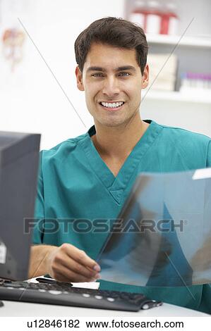 Young hospital doctor at desk View Large Photo Image Stock Image - Young hospital doctor at desk. Fotosearch