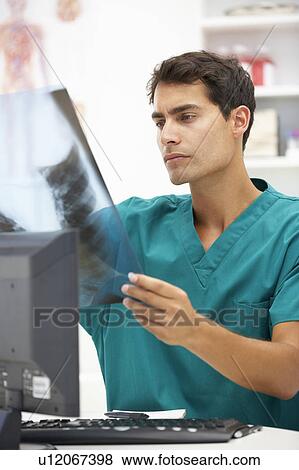 Stock Photo - Young hospital doctor at desk. Fotosearch