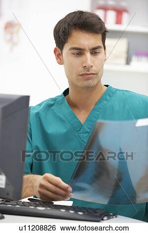 Stock Photograph - Young hospital doctor at desk. Fotosearch