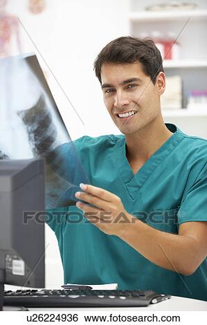 Stock Photograph - Young hospital doctor at desk. Fotosearch