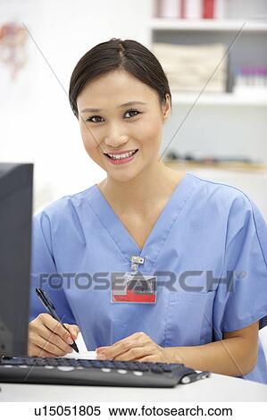Stock Photography - Young hospital doctor at desk. Fotosearch